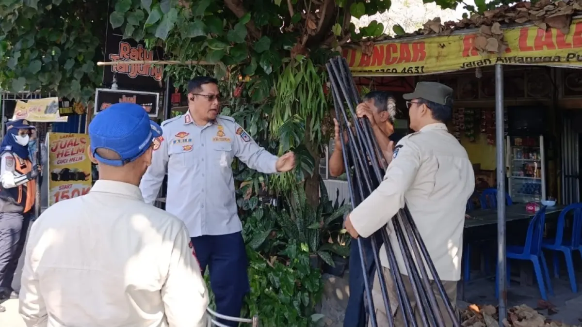 Kabid Dalops Dishub Mataram Arif Rahman saat menegur seorang pedagang yang memasang tenda lapak hingga mencaplok badan jalan.