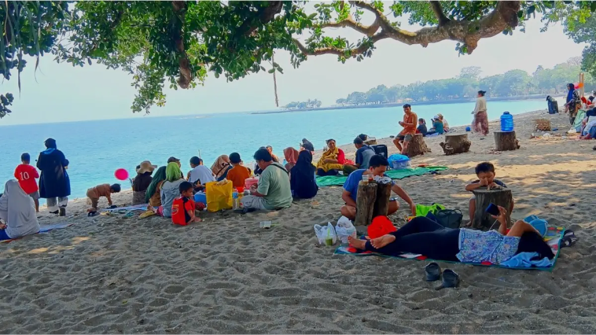 BERSANTAI: Pengunjung yang menikmati suasana liburan akhir pekannya di Pantai Locco, Senggigi, Ahad (2/8). (NURUL/LOMBOK POST)