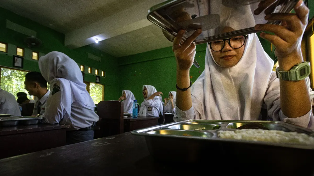 BUTUH PENANGANAN: Seorang siswa siap menyantap MBG beberapa waktu lalu. Adapun sisa makanan karena tak dihabiskan oleh siswa mesti menjadi perhatian. (IVAN/LOMBOK POST)