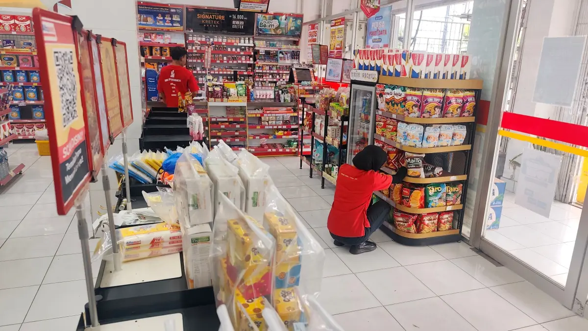 TIDAK SERIUS: Seorang karyawan Alfamart Renteng sedang merapikan produk makanan ringan, di Lombok Tengah beberapa waktu lalu.

