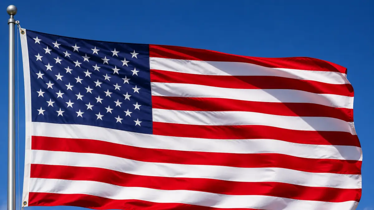 Bendera Amerika Serikat berkibar dengan latar langit biru, melambangkan persatuan, kebebasan, dan identitas nasional negara tersebut.