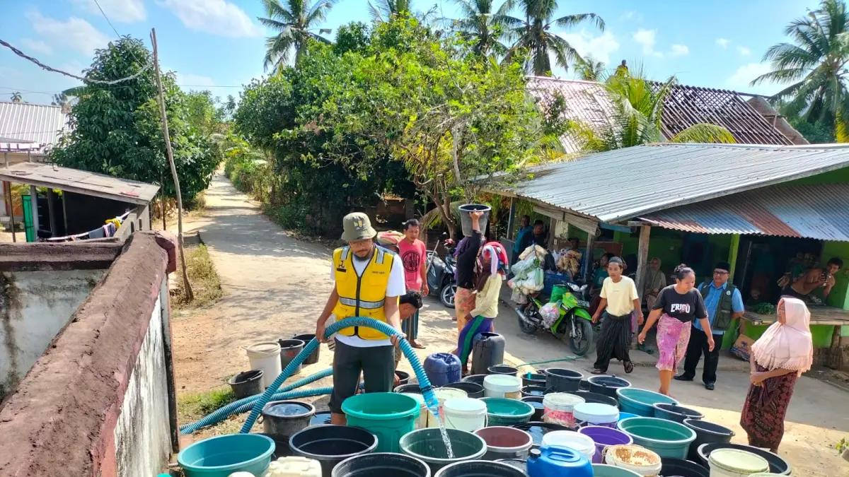 DAMPAK EL NINO: Sejumlah warga menampung air bersih menggunakan baskom dan wadah lainnya, dari mobil tangki Kementerian PU di wilayah terdampak kekeringan di Lombok Barat, belum lama ini. (DOK.BPBPK NTB)