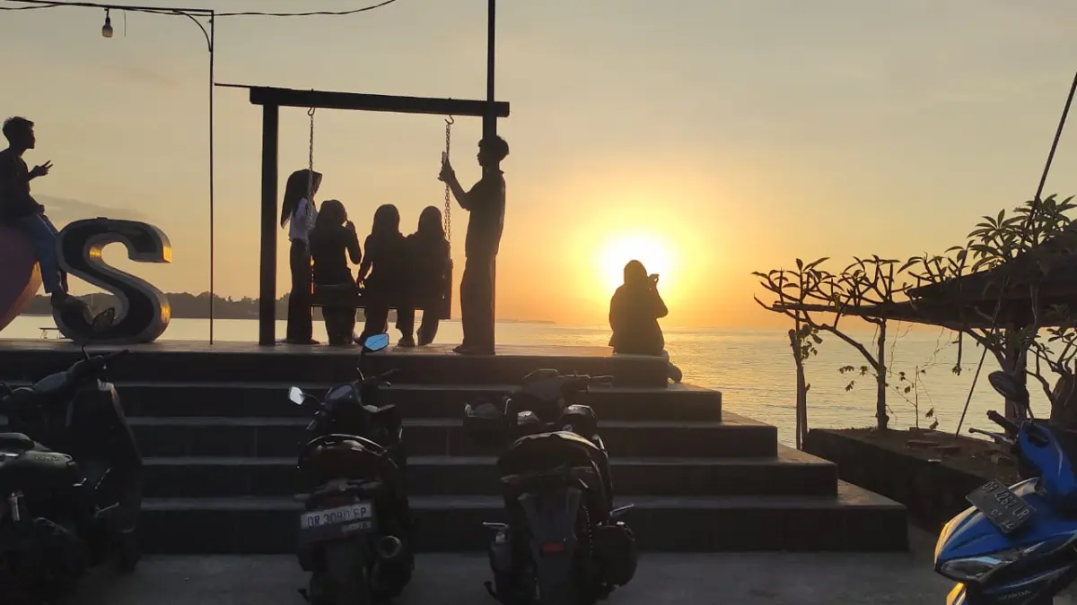MATAHARI TERBENAM: Pengunjung menikmati suasana sunset di Pantai Impos, Desa Malaka, Kecamatan Tanjung.