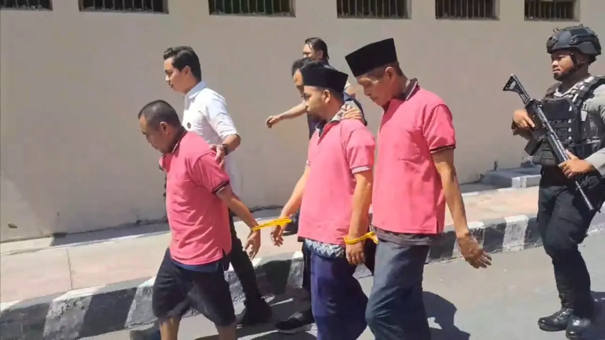 TERDUGA PELAKU: Tiga terduga pelaku pengedar uang palsu saat di tahan dan dibawa ke tahanan oleh anggota polisi di Polres Lotim. 