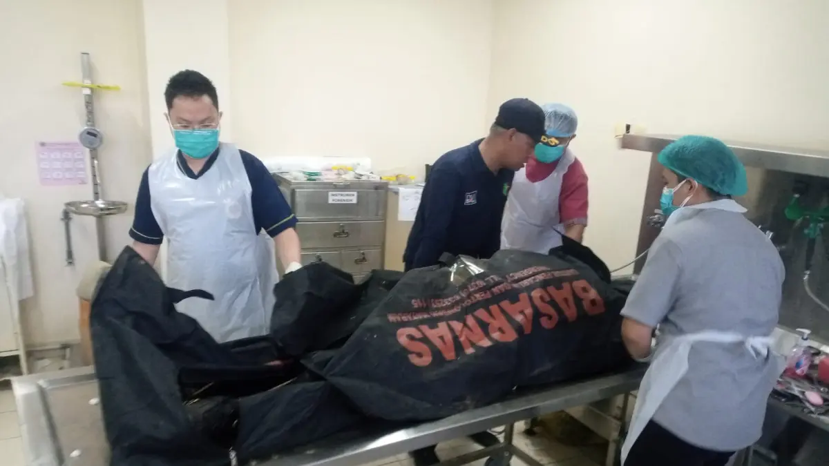 MASIH DIDALAMI: Mayat korban saat pemeriksaan luar setelah dievakuasi. Sejauh ini penyebab kematian korban belum dipastikan.