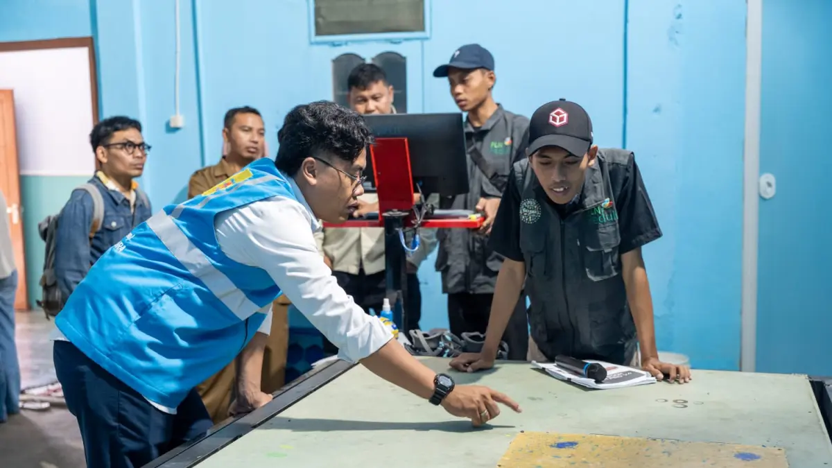 Officer Komunikasi & TJSL PLN UIP Nusra Raden Moh Ayman Nasir mengecek proses pemotongan material daur ulang menggunakan mesin CNC Router 3D dalam Workshop Daur Ulang bersama Komunitas Gelisah di Sanggar Kreatif Gelisah, Ampenan, Mataram.