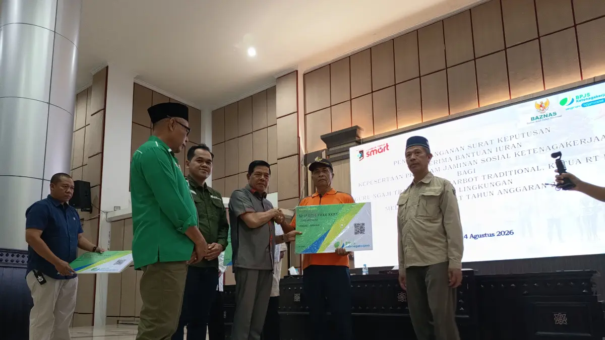 JAMINAN SOSIAL: Bupati Lombok Timur bersama Ketua Baznas, dan Kepala Cabang BPJS Ketenagakerjaan Lotim menyerahkan kartu BPJS ketenagakerjaan secara simbolis kepada guru ngaji dan marbot yang mendapatkan jaminan sosial. 
