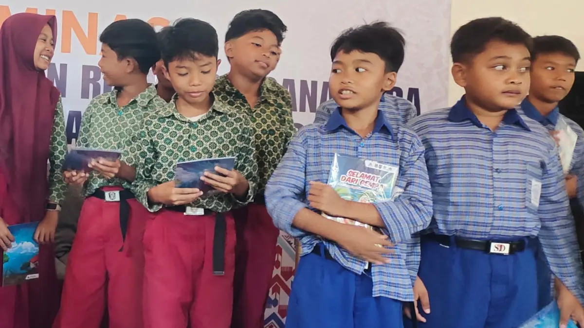 LITERASI: Para siswa SD di Lombok Utara memegang buku cerita bergambar berjudul "Selamat dari Bencana".