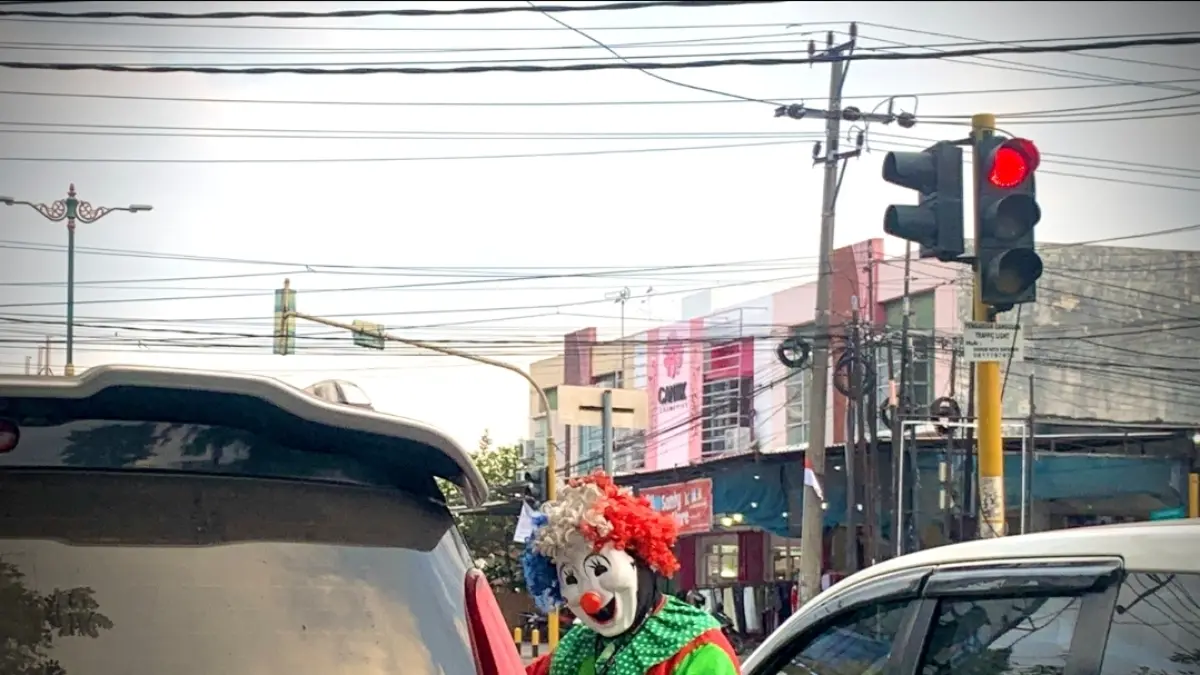 Pengamen berkostum badut tampak mendatangi mobil saat lampu merah di salah satu sudut jalanan Kota Mataram. Maraknya aksi ini mendapat perhatian dari Pemkot Mataram untuk dilakukan penataan secara lebih teratur dan humanis.
