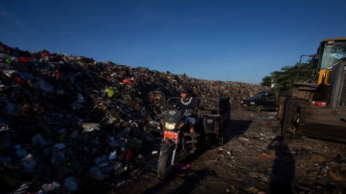 Seorang petugas kebersihan roda tiga sedang membuang sampah di TPS, beberapa waktu lalu. 
