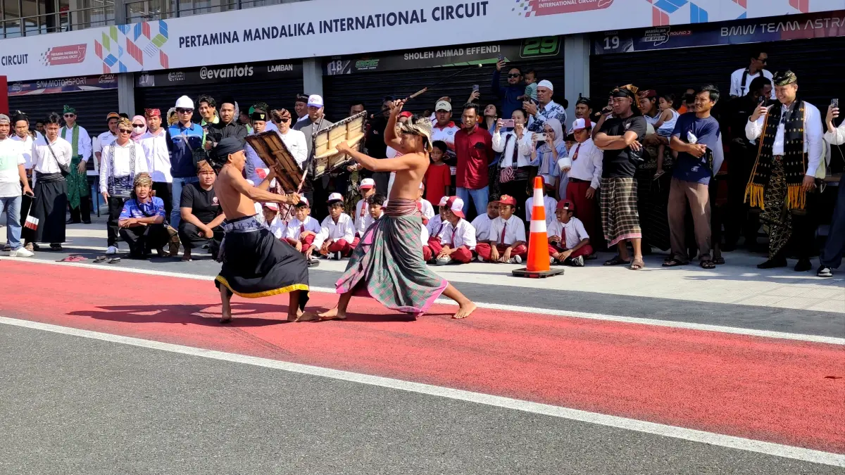 Atraksi dua orang pepadu dalam aksi peresean menyita perhatian para murid sekolah dan pengunjung Sirkuit Internasional Mandalika usai upacara HUT ke-81 Republik Indonesia, Senin (17/8).