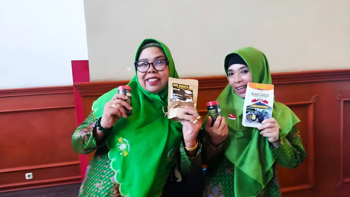 BERKHASIAT: Syaeun (kanan) menunjukkan produk black garlic miliknya, beberapa waktu lalu. (IST/LOMBOK POST)