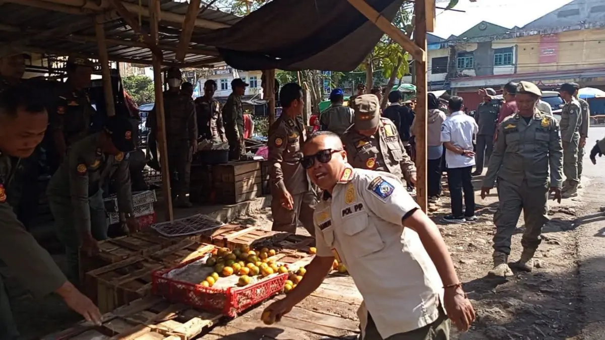 PENERTIBAN: Petugas Satpol PP Loteng menertibkan puluhan lapak pedagang yang berjualan di bahu dan trotoar jalan depan Pasar Renteng, Leneng, Praya, Rabu (19/8). Penertiban juga dilakukan pada kendaraan yang parkir di bahu jalan raya depan Rumah Sakit Cahaya Medika.