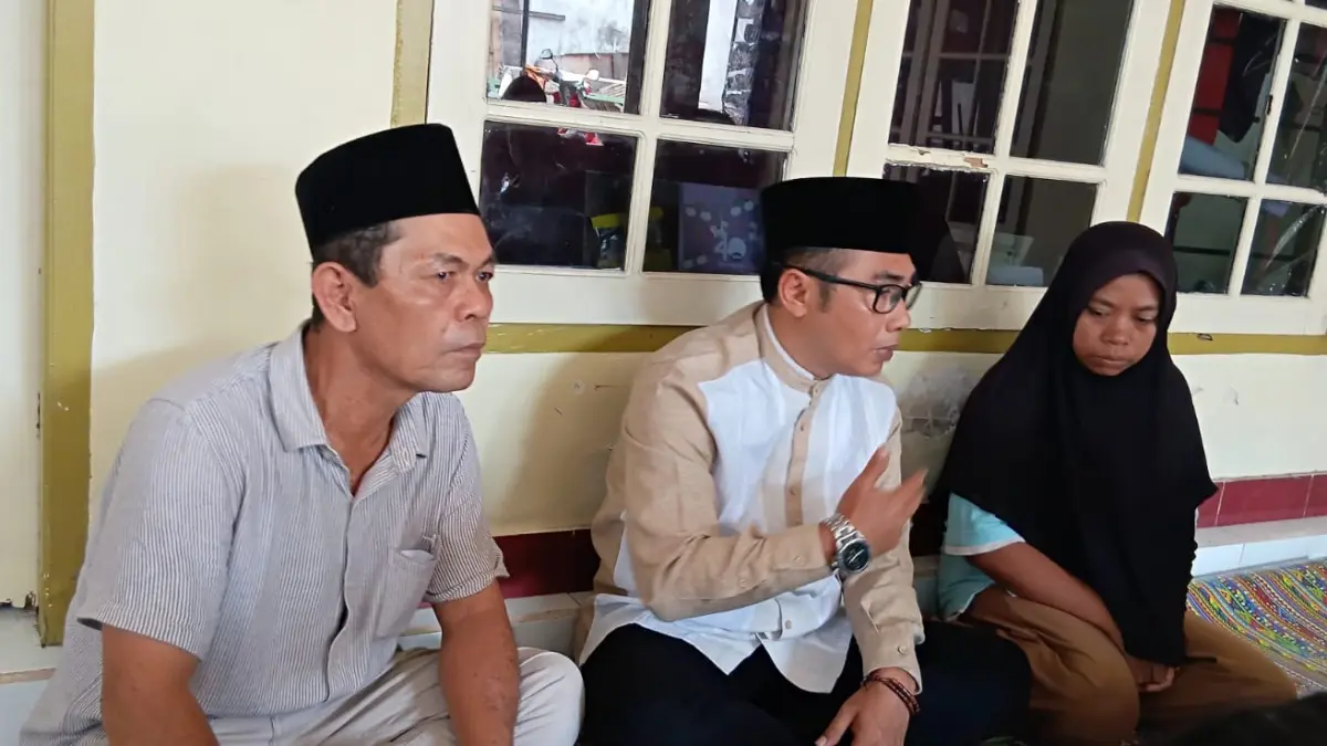 Kepala Desa Gelogor, Achmad Arman Iswara (tengah) saat mendampingi istri korban KMP Putri Yasmin usai pemakaman Ardiansyah di Pemakaman Umum Desa Gelogor, Kamis (20/8). (NURUL/LOMBOK POST)