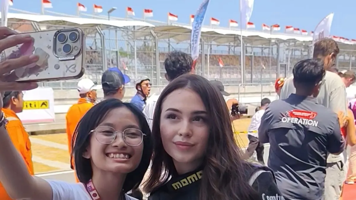Pembalap wanita Amara Angelica berswafoto hingga membagikan stiker kepada para penggemar saat sesi pitwalk di ajang Mandalika Festival of Speed (MFoS) seri ketiga di Sirkuit Internasional Mandalika, Minggu (16/8).