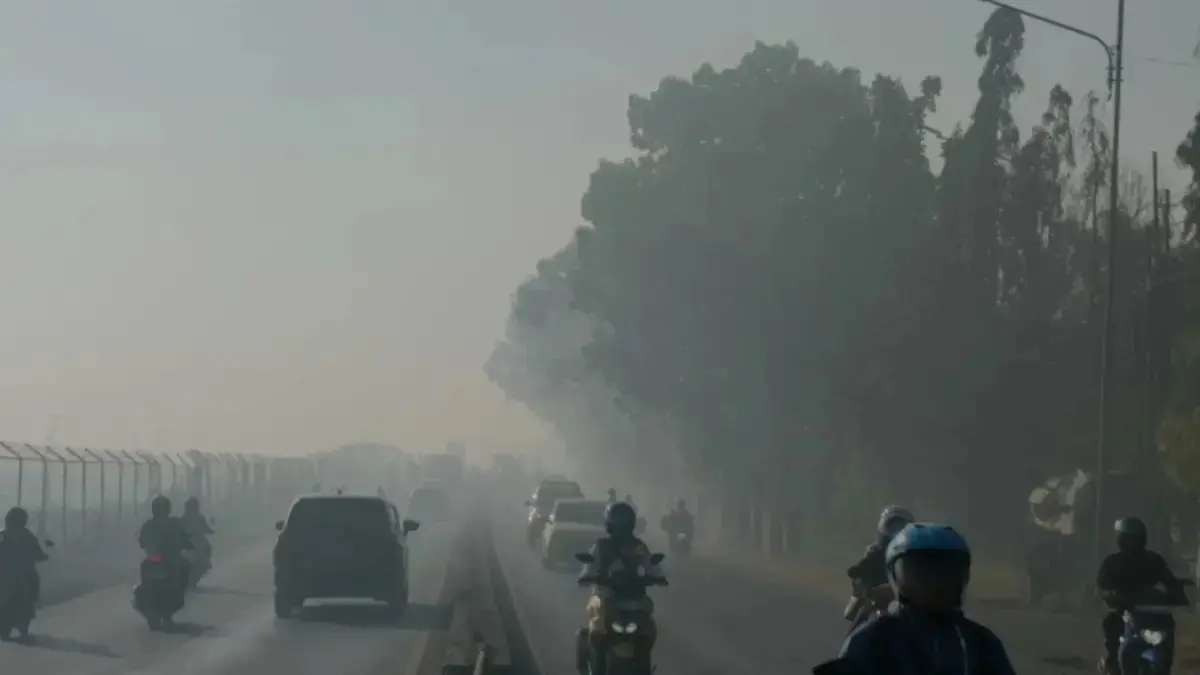 Warga melintas di sepelah kawasan BAndara internasional Syamsudin Noor Banjarbaru, Rabu (19/8) di tengah kabut asap yang pekat. (Sheilla/Radar Banjarmasin)