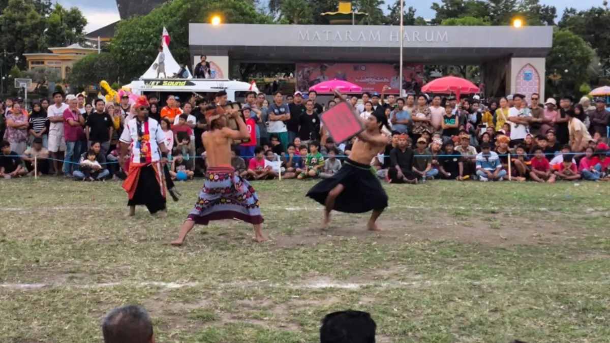 Dua pepadu tengah adu ketangkasan di arena peresean yang digelar Dinas Pariwisata dalam rangka menyambut HUT ke-33 Kota Mataram di Lapangan Sangkareang, Minggu (23/8).