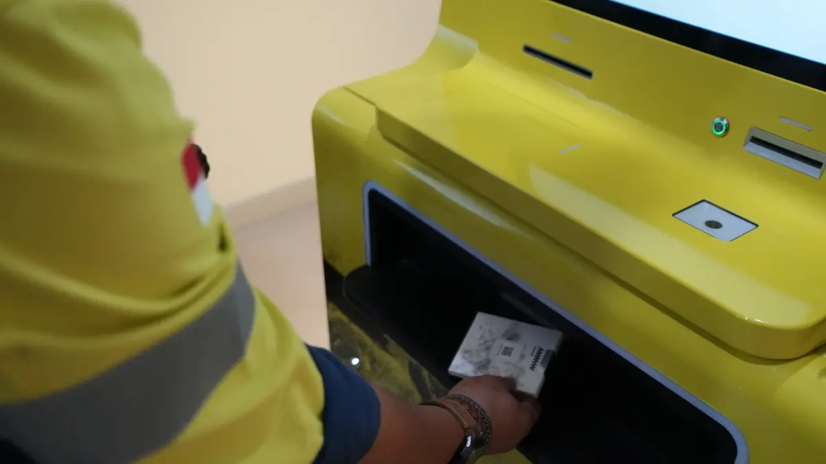 Karyawan AMMAN mengambil emas batangan usai melakukan transaksi di AMMAN Gold ATM.