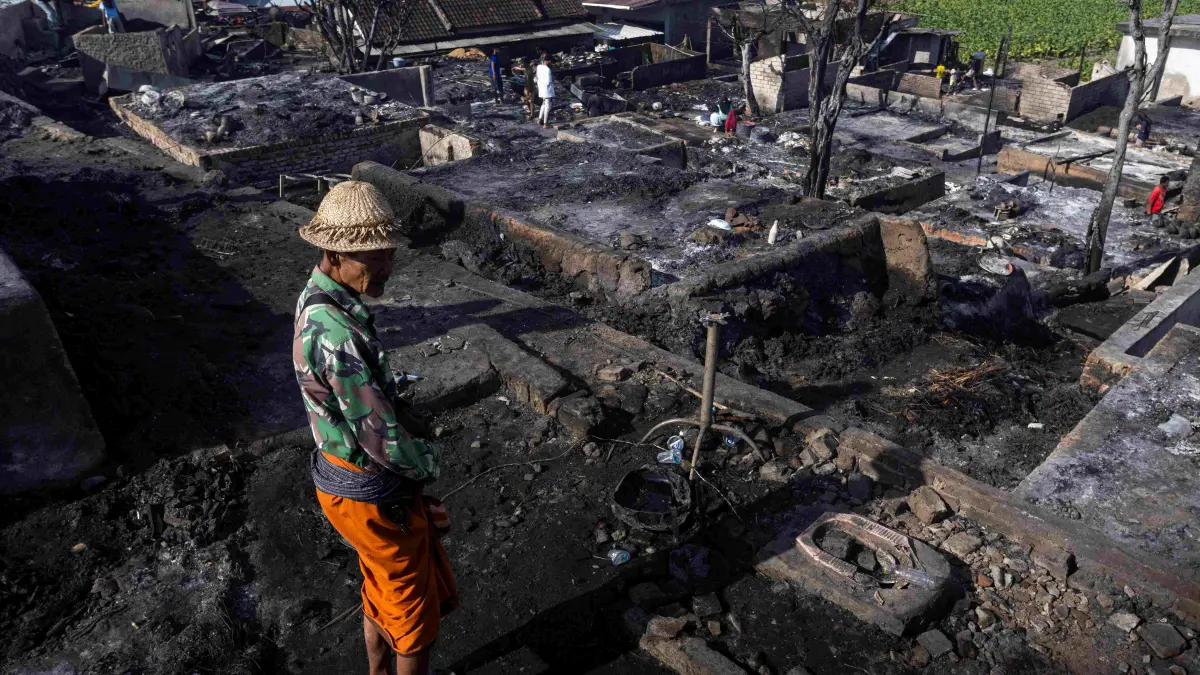 PUING KEBAKARAN: Seorang warga berdiri di antara reruntuhan bangunan yang hangus terbakar di area permukiman Desa Adat Sade, Rembitan, Lombok Tengah, Minggu (23/8). (IVAN/LOMBOK POST)
