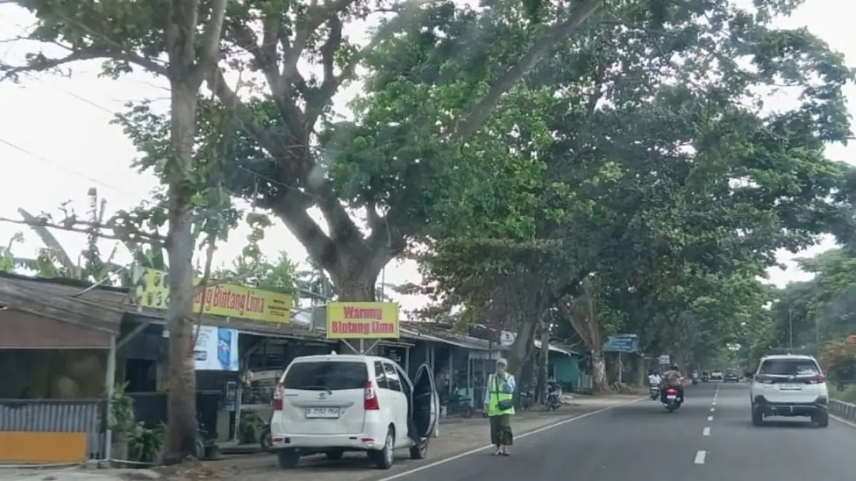HARUS TERTIB: Seorang jukir di Bunderan Gerung saat memarkirkan kendaraan, Selasa (25/8). (NURUL/LOMBOK POST)