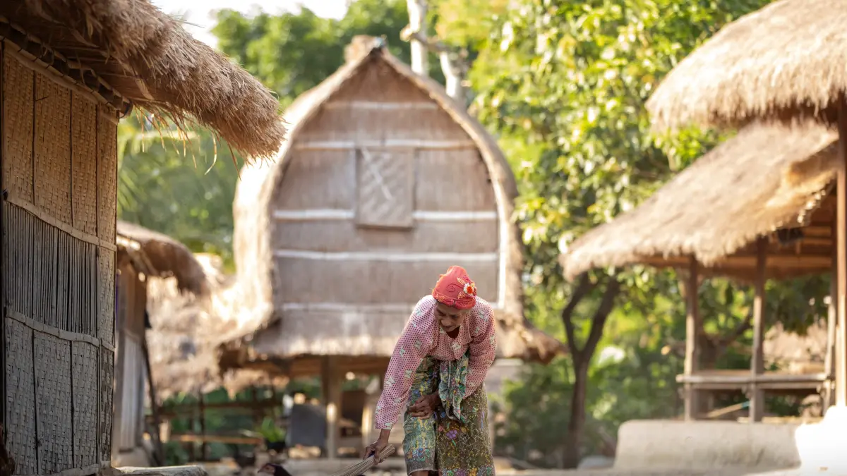 BUDAYA TERJAGA: Seorang wanita lansia suku Sasak menyapu halaman pelataran Desa Adat Ende di Lombok Tengah, beberapa waktu lalu. (IVAN/LOMBOK POST)