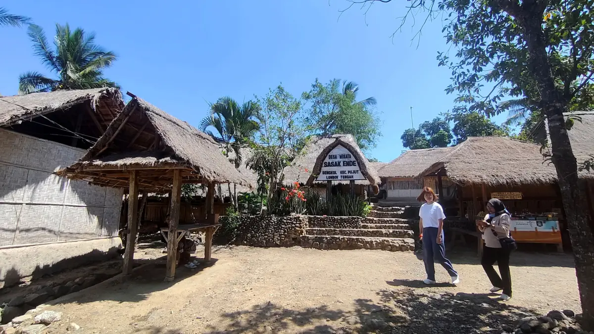 Dua orang wisatawan berjalan usai mengunjungi Desa Wisata Sasak Ende di Desa Sengkol, Pujut, Lombok Tengah, Rabu (26/8).