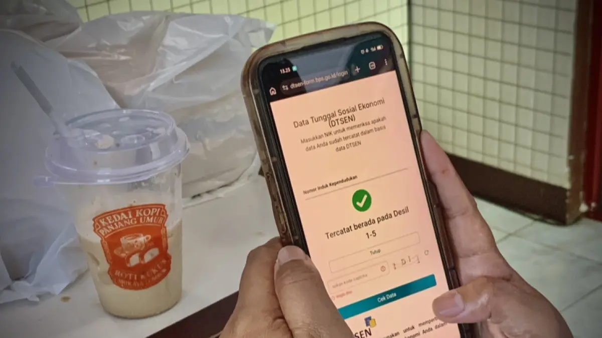 Seorang warga menunjukkan hasil pengecekan Data Tunggal Sosial Ekonomi (DTSEN) melalui layar telepon seluler