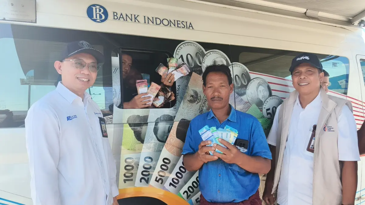 Kepala Perwakilan BI NTB Hario K. Pamungkas (kiri) berfoto bersama Marwan korban kebakaran di Desa Wisata Sade (tengah) saat menukarkan sisa-sisa rupiah miliknya yang terbakar pada pelayanan mobil Kas Keliling BI di Pasar Sengkol, Desa Sengkol, Pujut, Lombok Tengah, Rabu (26/8).
