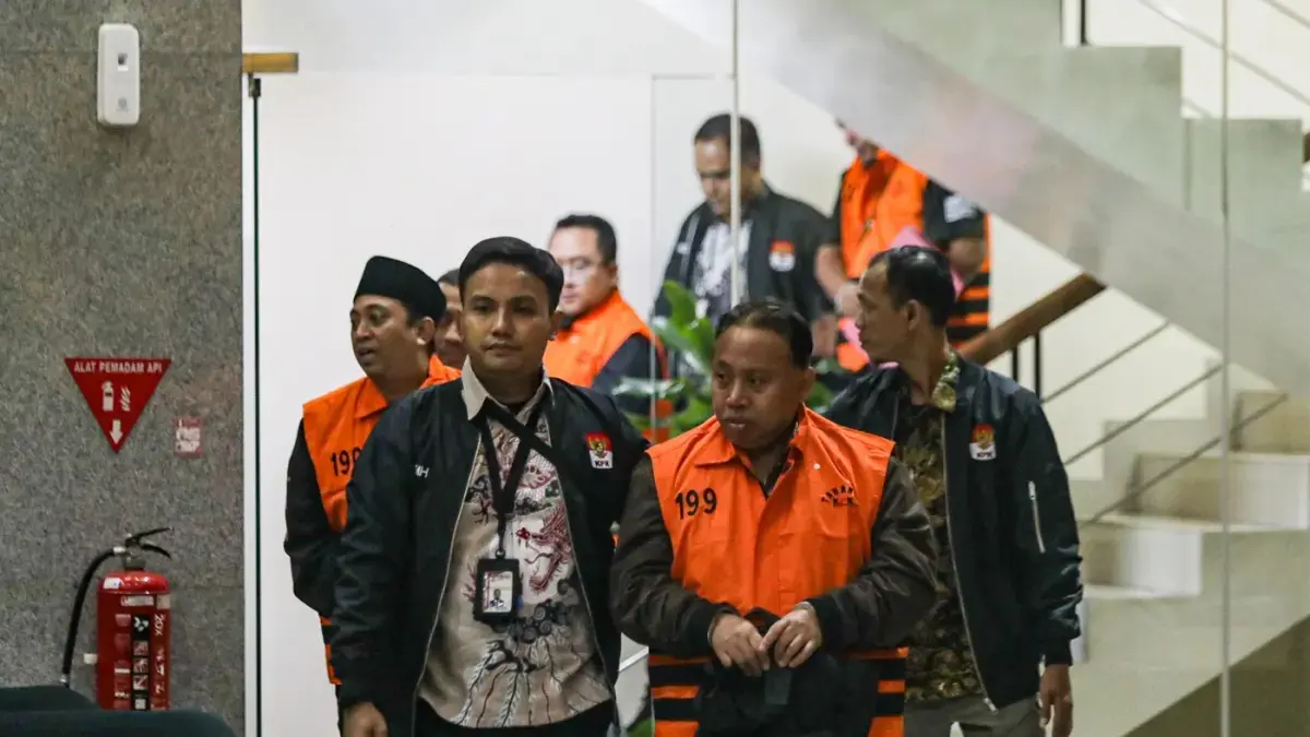 Rektor Universitas Jenderal Soedirman (Unsoed) Akhmad Sodiq berjalan menuju mobil tahanan seusai menjalani pemeriksaan di Gedung Merah Putih KPK, Jakarta, Sabtu (22/8/2026) dini hari. (Salman Toyibi/Jawa Pos)