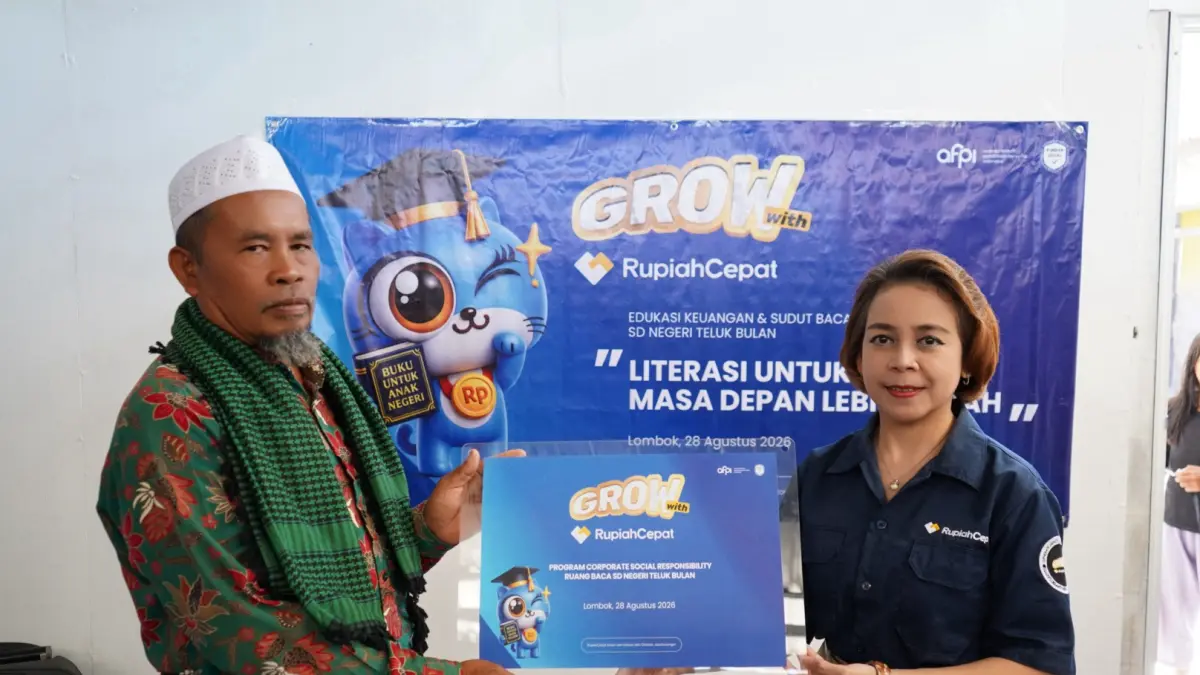Direktur Utama PT Kredit Utama Fintech Indonesia (RupiahCepat), Balandina Siburian (kiri), menyerahkan bantuan pojok baca kepada Kepala SD Negeri Teluk Bulan, H. Sukur, S.Pd. (kanan) pada Jumat, 28 Agustus 2026 di Lombok Tengah.