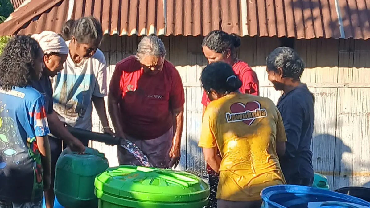 Masyarakat Lewokoba, Desa Atakore, berkumpul mengisi gentong saat air bersih mulai mengalir dan menjangkau permukiman mereka.
