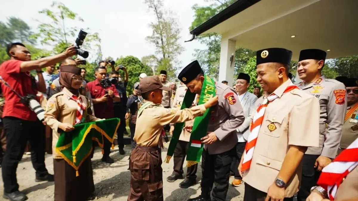 Peserta Pramuka PUI mengalungkan kenang-kenangan ke Kapolri Listyo Sigit Prabowo saat menghadiri apel kebangsaan kemah nasional di Sukabumi, Kamis (3/9). (Mabes Polri)