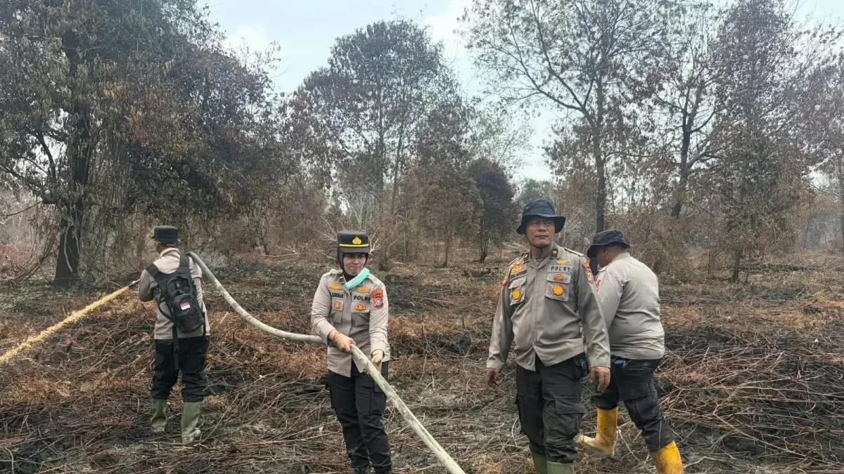 Personel Polda Riau melakukan pemadaman di kawasan karhutla. (Istimewa)