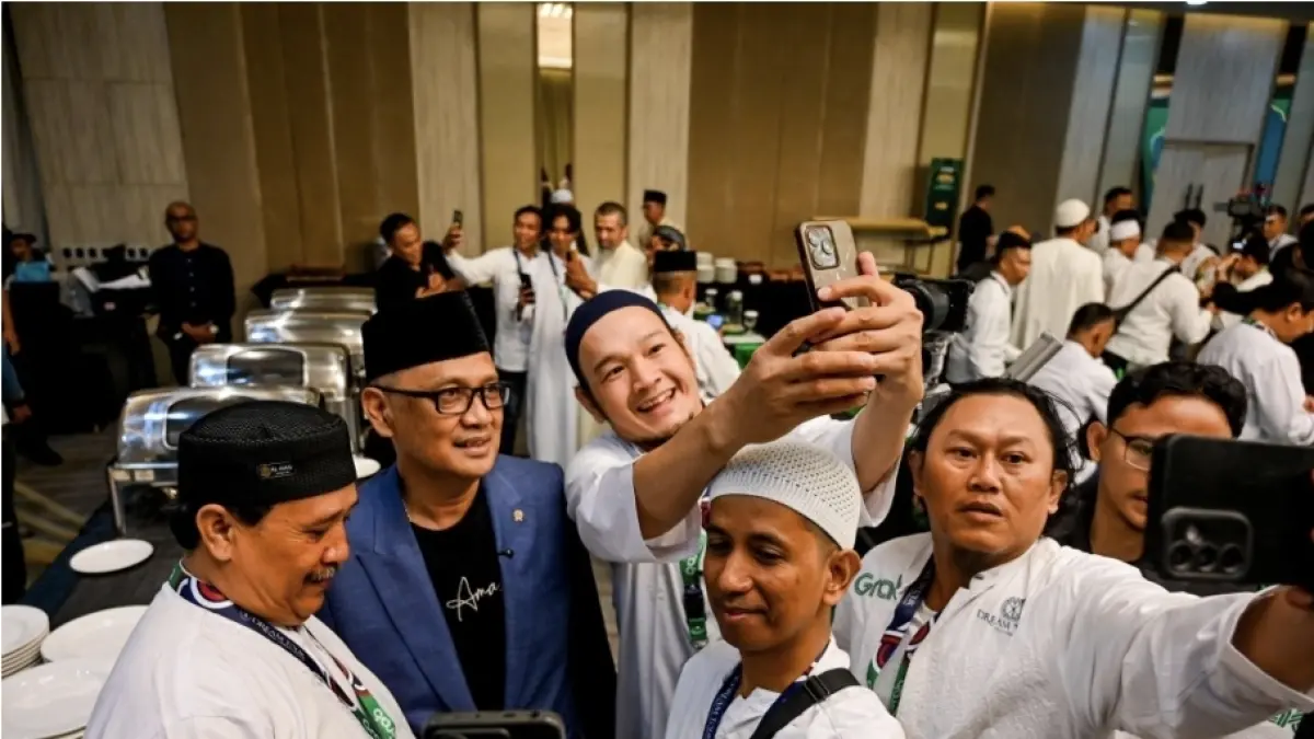 Para Mitra Pengemudi Grab penerima Program BERKAH (Berangkat Umrah) mengabadikan momen kebersamaan dengan Mochamad Irfan Yusuf, Menteri Haji dan Umrah Republik Indonesia dalam prosesi keberangkatan 105 Mitra Pengemudi Grab pemenang program Berangkat Umrah (BERKAH) di Tangerang, Sabtu (12/9). (ist)