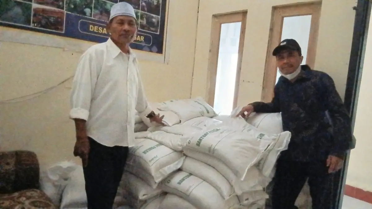 MASIH MENUMPUK: Pemdes Gelangsar menunjukkan beras yang masih menumpuk belum bisa dibagikan di Kantor Desa Gelangsar, Jumat (11/9). (NURUL/LOMBOK POST)