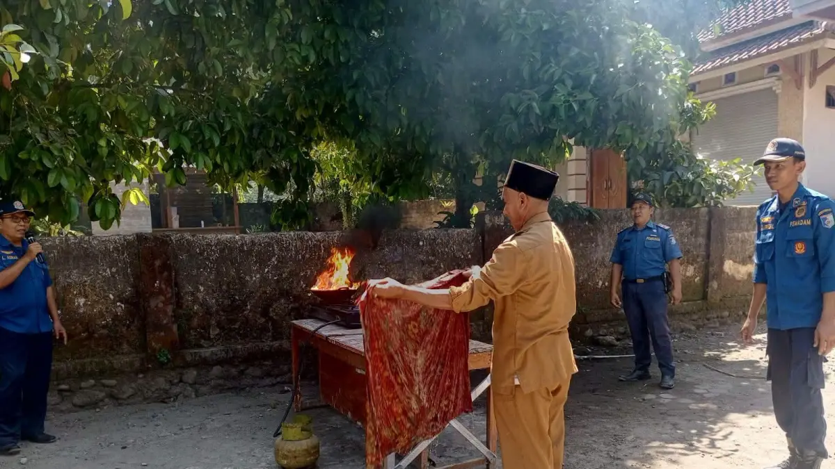 SIMULASI: Salah satu pegawai kantor desa saat simulasi penanganan kebakaran di Kantor Desa Lembah Sempage, Senin (14/9). (DAMKARMAT FOR LOMBOK POST)