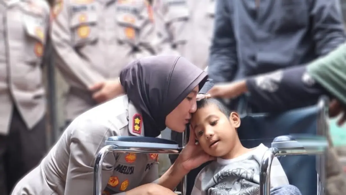 SENTUHAN KASIH SAYANG: Kapolres Lobar AKBP Mellysa Amalia mencium Faizal Rahman yang berjuang dengan sakitnya di desa Leleda, pekan lalu. (POLRES LOBAR FOR LOMBOK POST)