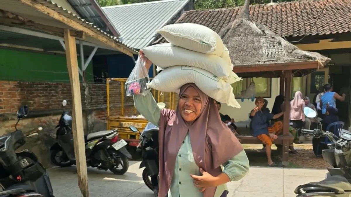 AMBIL BERAS: Seorang warga saat mengambil beras bantuan sosial di Kecamatan Lembar, beberapa hari lalu. (IST/LOMBOK POST)