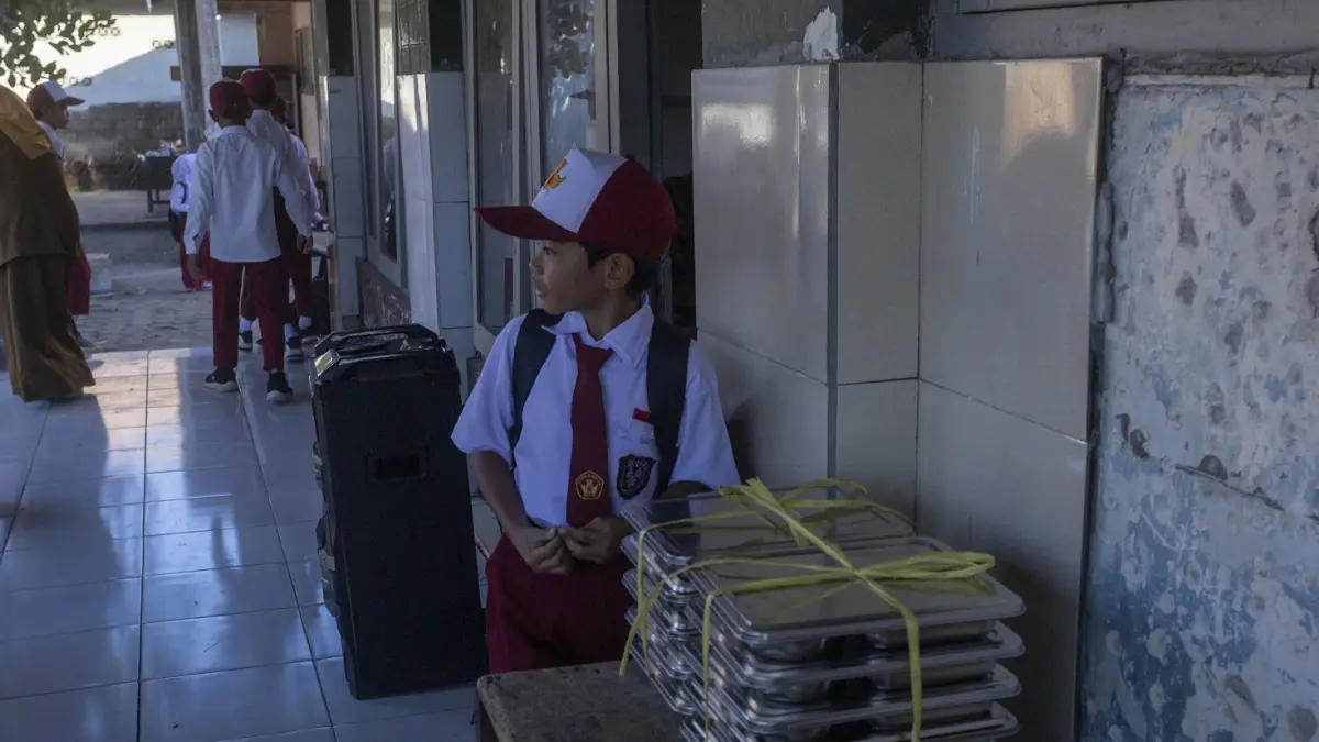 HARUS HIGIENIS: Seorang murid di Kota Mataram saat mengambil MBG dalam omprengan, belum lama ini. SPPG Mataram diminta perketat higienitas MBG.