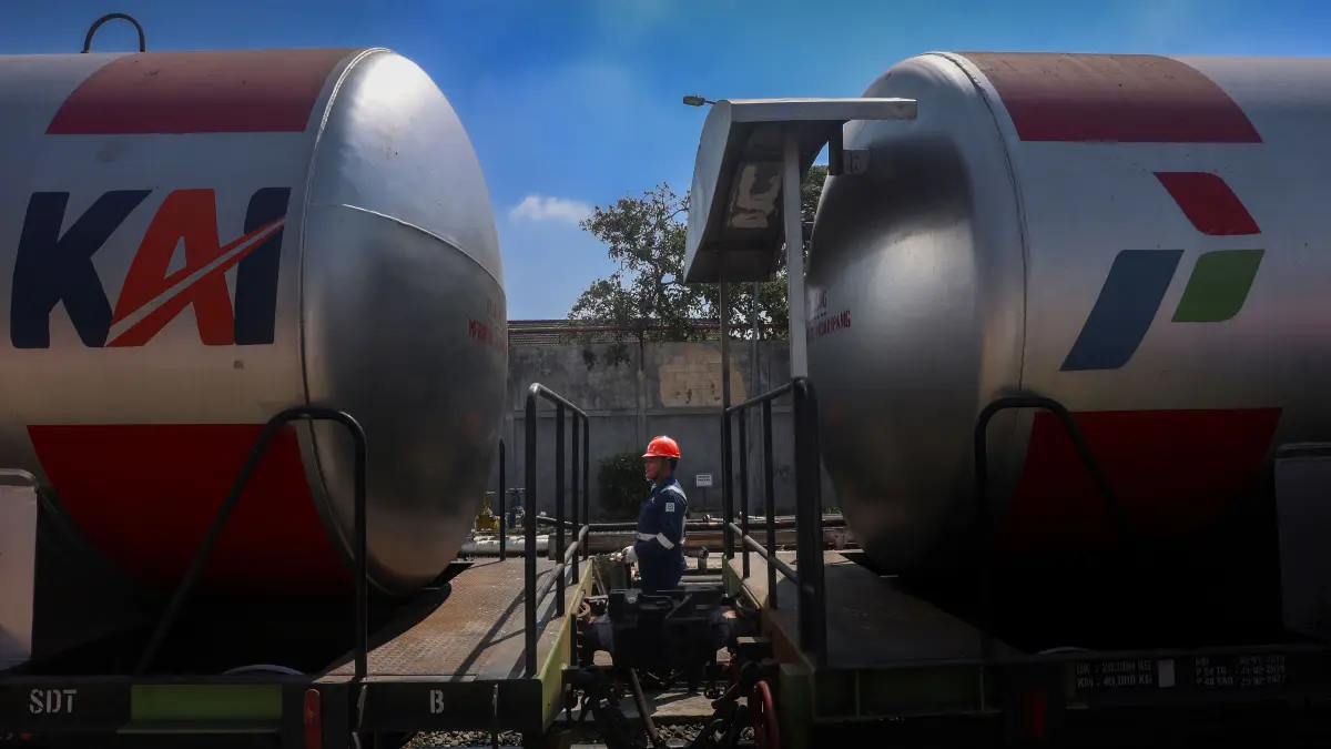 Integrasi Logistik: Seorang petugas berada di antara rangkaian gerbong Kereta Api Ketel (KKW) BBM saat proses pembongkaran muatan massal di jalur rel FT Malang (2/9/2026). Efisiensi moda rel ini menopang kebutuhan konsumsi harian warga yang mencapai jutaan liter per hari.