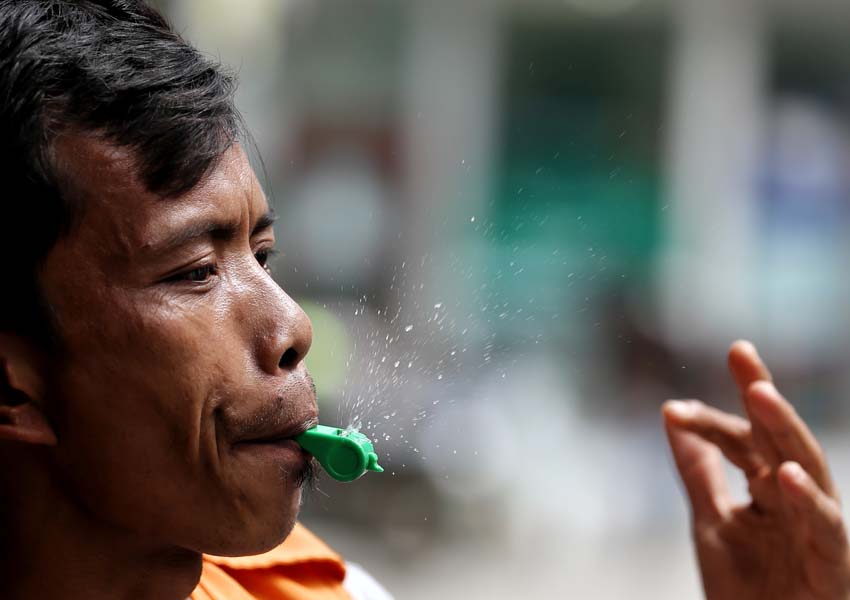 SEMANGAT KERJA: Seorang tukang parkir meniup peluitnya dengan penuh semangat di salah satu ritel perbelanjaan Kota Mataram, kemarin (15/1). Saking semangatnya air liurnya sampai keluar dari peluit yang ditiupnya.