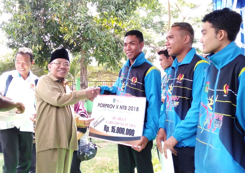 SERAHKAN: Bupati KLU H Najmul Akhyar memberikan bonus pada juara lari 100 meter porprov Lalu Muhammad Zohri serta sejumlah atlet lainnya di halaman Kantor Dikpora KLU, Senin lalu (31/12).