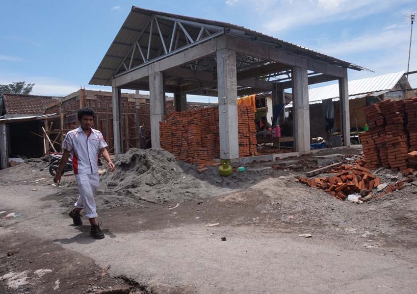 HAMPIR RAMPUNG: Seorang warga melintas di depan rumah instan sederhana (Risha) yang dibangun di Lingkungan Tegal, Kecamatan Sandubaya beberapa hari lalu.