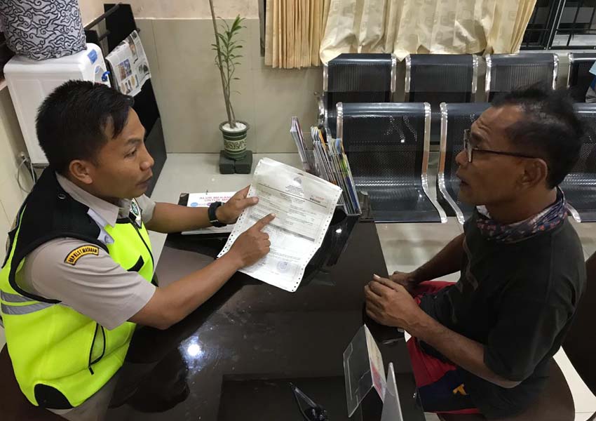 PERIKSA SURAT MENYEBERANG: Petugas Balai Karantina Kelas I Mataram Wilker Kayangan Labuhan Lombok sedang memeriksa surat izin seorang sopir yang mengangkut telur ke Bima, belum lama ini.