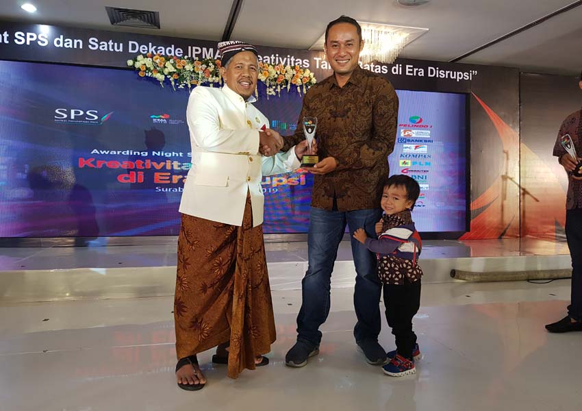 THE BEST: Ketua Harian SPS Pusat Ahmad Djauhar (kiri) menyerahkan tropi IPMA kepada Pemred Lombok Post Jony Marthadinata di ballroom Gedung Siola Surabaya, Kamis malam (7/2).