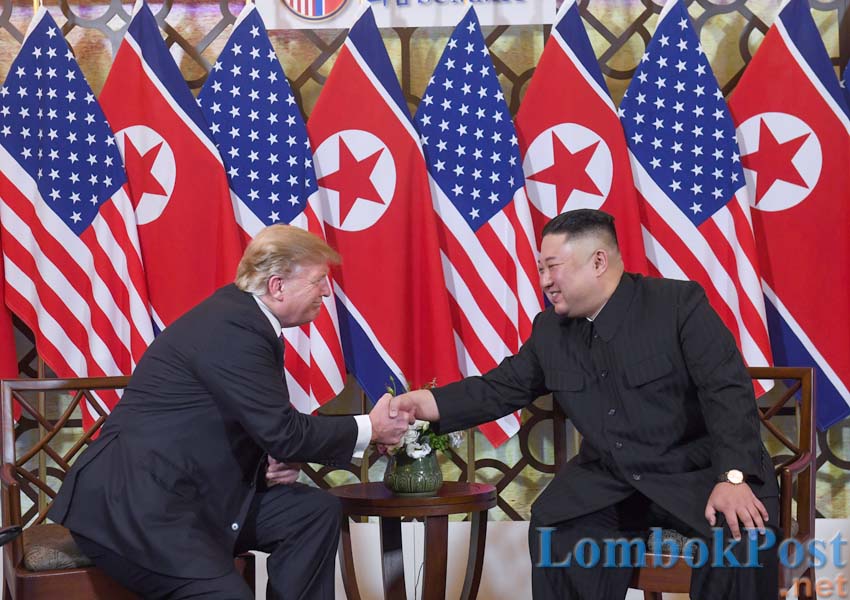 SALING PUJI: Presiden Amerika Serikat Donald Trump dan Pemimpin Korea Utara Kim Jong-un saling berjabat tangan dalam pertemuan sesi pembuka KTT kedua negara di Hanoi, Vietnam, kemarin (27/2). Ini pertemuan pemimpin negara yang tadinya berseteru, setelah p