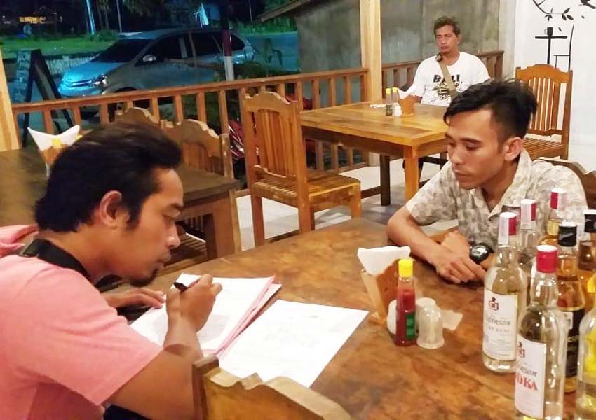 SURAT PERINGATAN: Personel Satnarkoba Polres Lombok Tengah, saat menulis surat peringatan bagi pedagang miras di Desa Kuta, Pujut, Minggu (17/2).