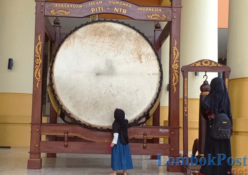 UKURAN RAKSASA: Beberapa orang melintas di dekat beduk Masjid Hubbul Wathan, Islamic Center. Lokasi ini pernah menjadi tuan rumah penyelenggaraan MTQ Nasional 2016 lalu.