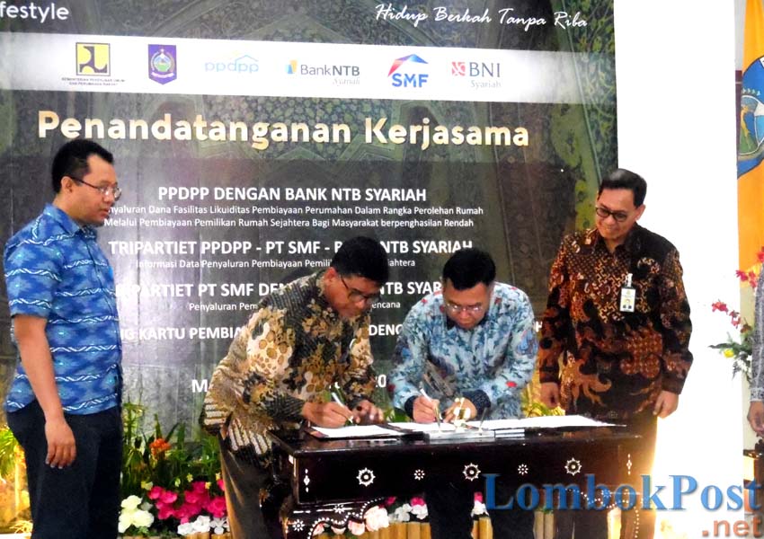 TANDA TANGAN: Direktur Utama PT Bank NTB Syariah H Kukuh Rahardjo (dua dari kiri) disaksikan Gubernur NTB H Zulkieflimansyah (kiri) dan para mitra, menandatangani perjanjian kerja sama di Pendopo Gubernur, kemarin (28/2).