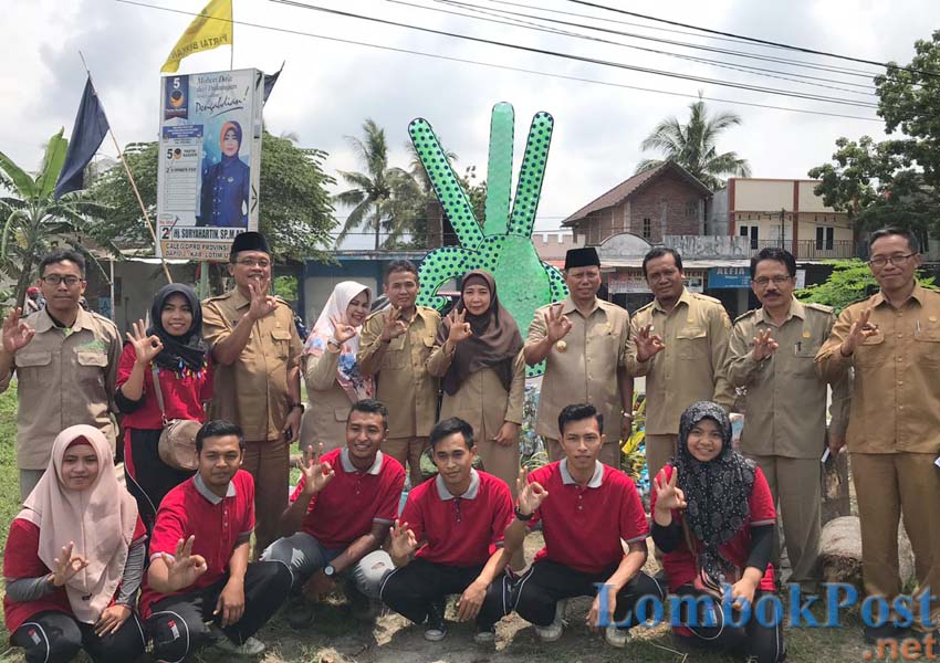 PEJUANG SAMPAH: Kades Dasan Lekong LM Rajabul Akbar (tiga dari kanan) foto bersama Bupati Lotim HM Sukiman Azmy (empat dari kanan) dan Wagub NTB Hj Sitti Rohmi Djalilah (lima dari kanan) bersama para punggawa bank sampahnya di Lapangan Umum Dasan Lekong,